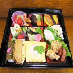 唐揚げや野菜の煮物、フルーツのデザートなどが入った重箱