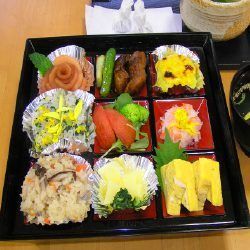 照り焼きチキンやたまご焼きと、サラダやおからなどが入った重箱