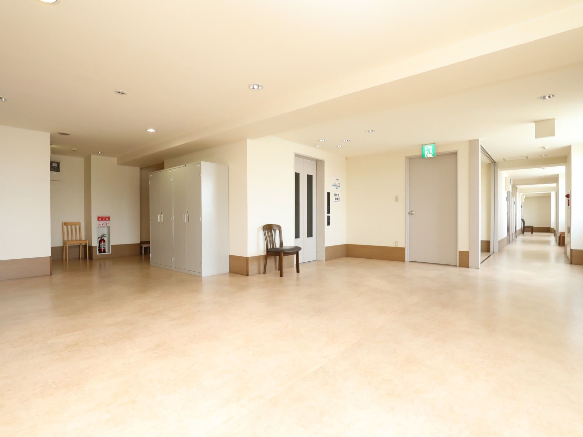 アイボリーを基調とした壁と天井で、明るい雰囲気の廊下である。ところどころに椅子が配置され休めるようになっている。