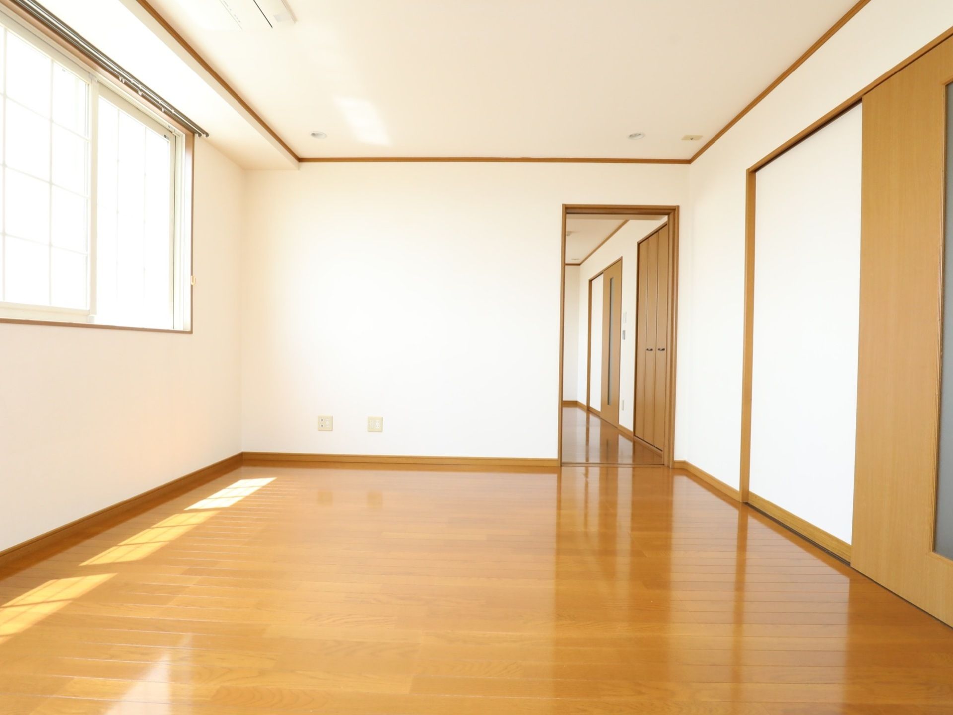 白い壁、木の床とドアの居室は、窓から光が差し込み明るく広々としている。また、ドアのサイズと同じくらい大きな鏡もある。