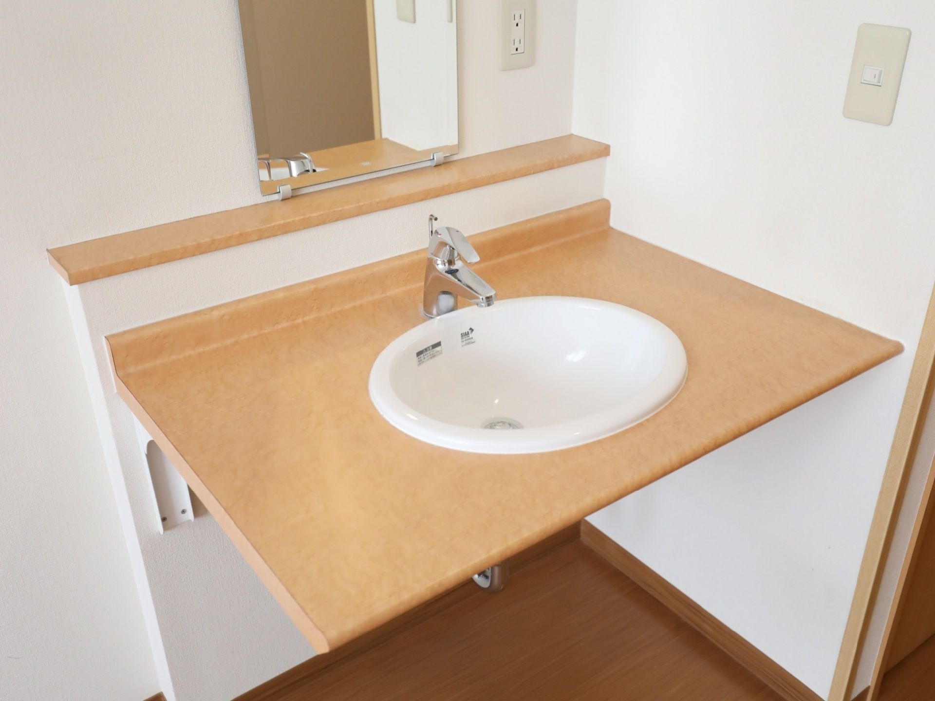 各居室備え付けの洗面台。水を受ける陶器の本体には、部屋の雰囲気に合わせた色をした大きな天板が取り付けられている。
