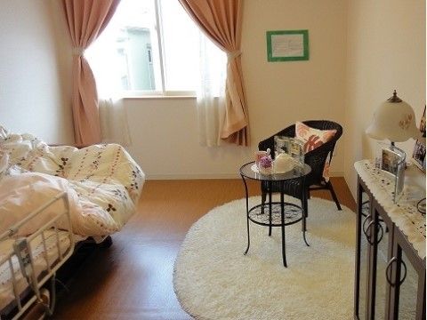 フローリングの床と白い壁に囲まれた居室は、お好みの家具を置き、お使いいただける。窓があり、介護用ベッドが置かれている。