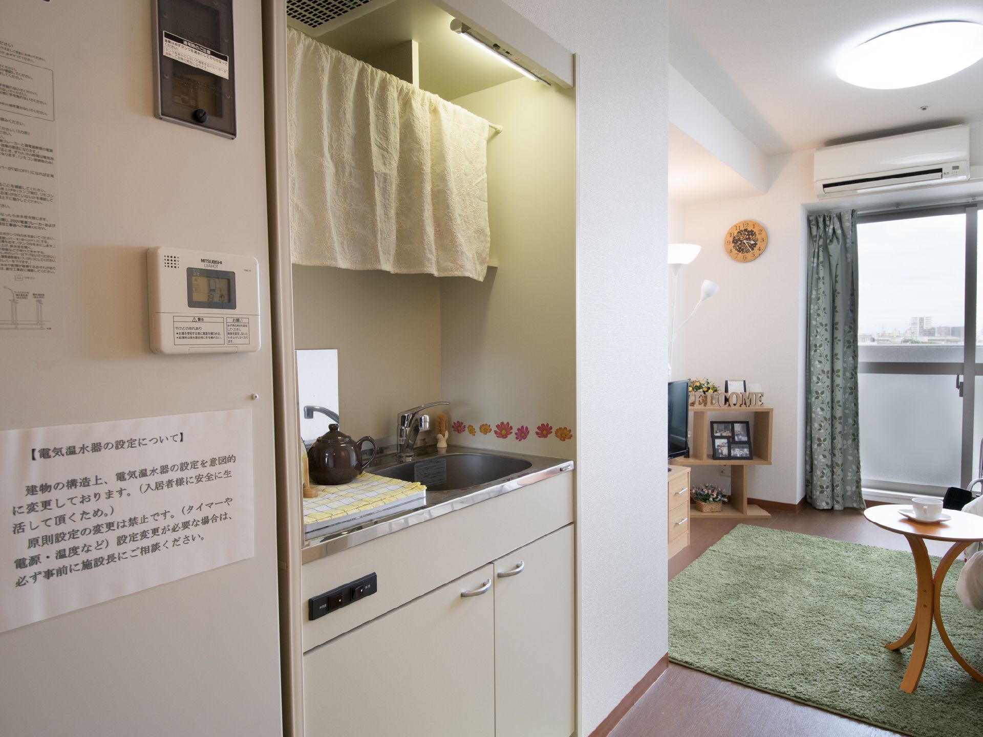居室には換気扇付きの小さなキッチンが付いている。エアコンも設置されていて、大きな窓からは景色が良く見える。