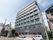 9階建ての建物で、施設前には駐車場がある。玄関前に飲み物の自動販売機が設置してある。木が植えられている。