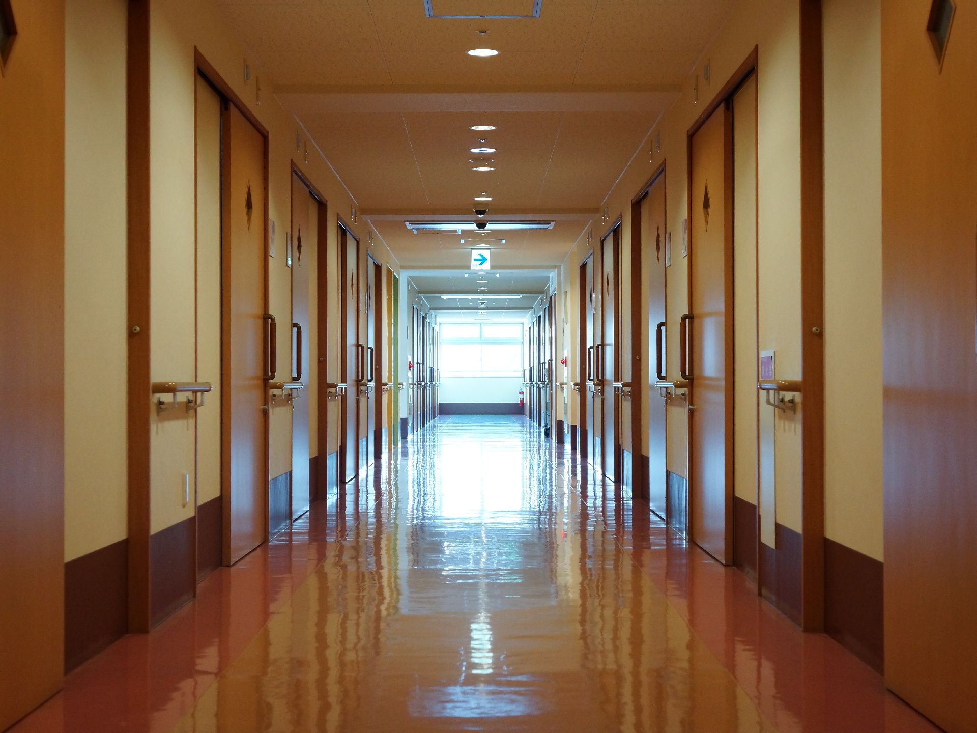 廊下はフローリングで障害なく歩き、車いすで通れる。扉以外には手すりが壁側についているので掴まって歩きやすい。