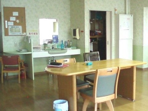 フローリングの床の上に２人掛けのダイニングチェアセットが１つ。部屋の奥には洗面台が設置されている。