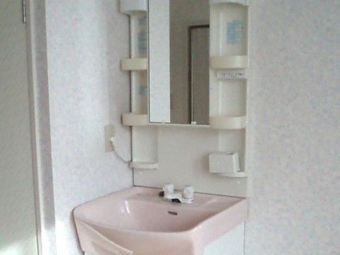 化粧台がピンク、収納部分が白色の洗面台