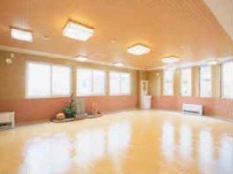 体育館のような部屋。家具は置いていない。壁の左右に複数の窓がある。