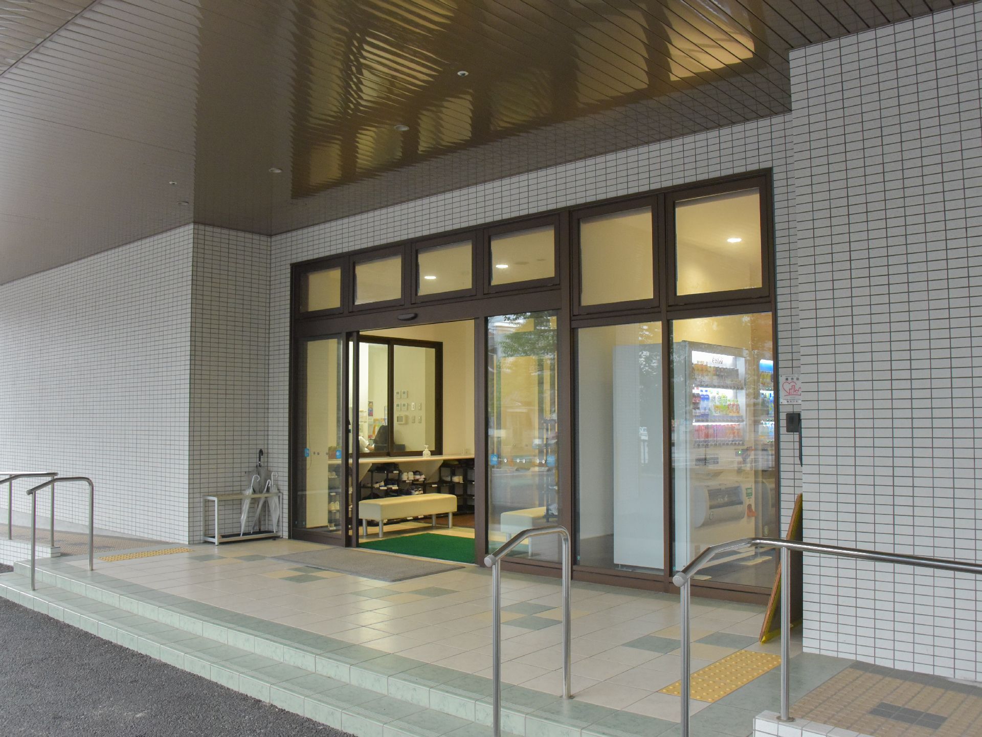 外側から見た玄関エントランス。手すりと車椅子用のスロープがある。玄関屋根が大きいので、雨に濡れず済む。
