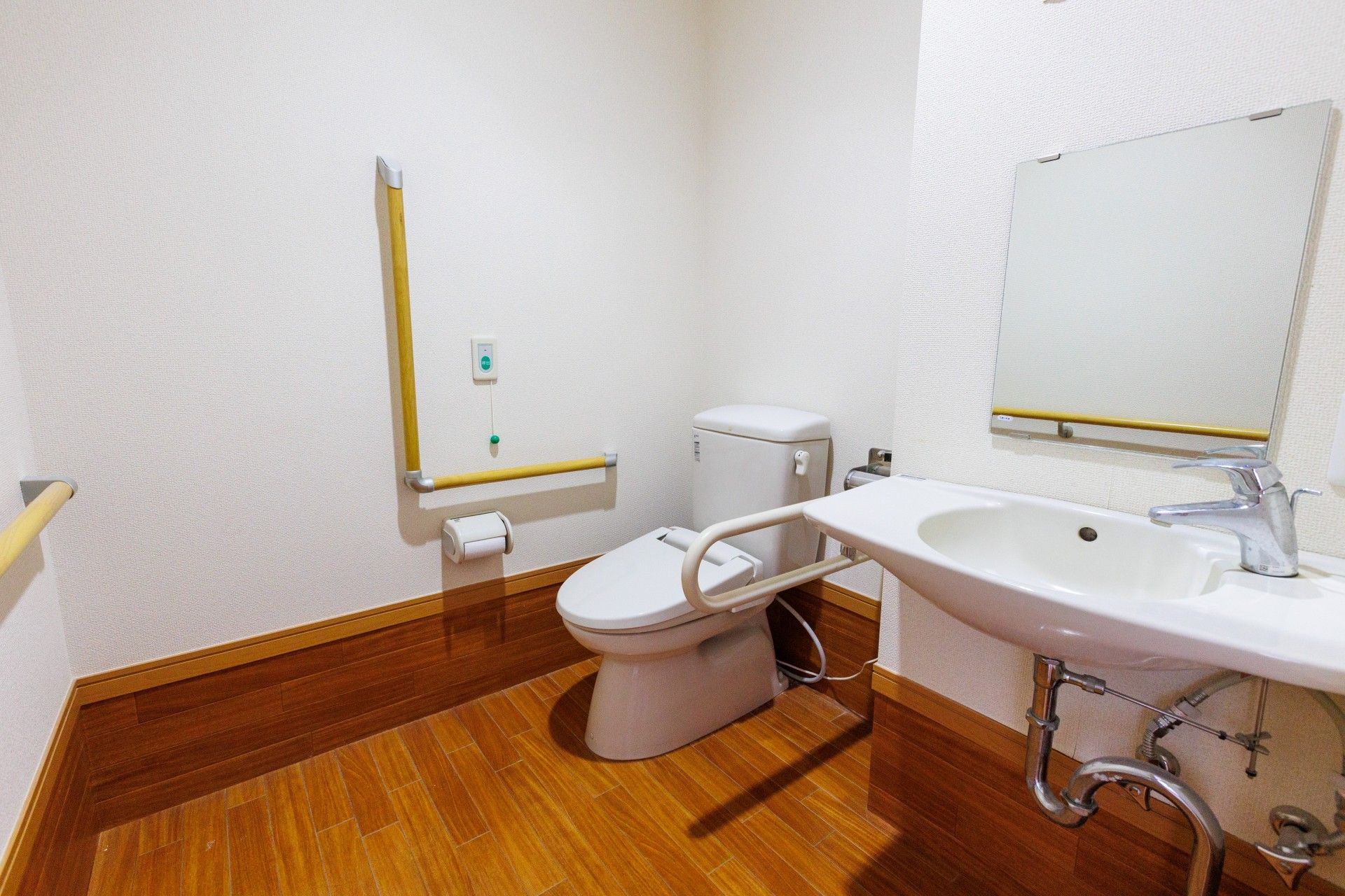 スペースが広いトイレには手すりが備えつけられている。呼び出しボタンも用意されており、手洗い場も設けられている。