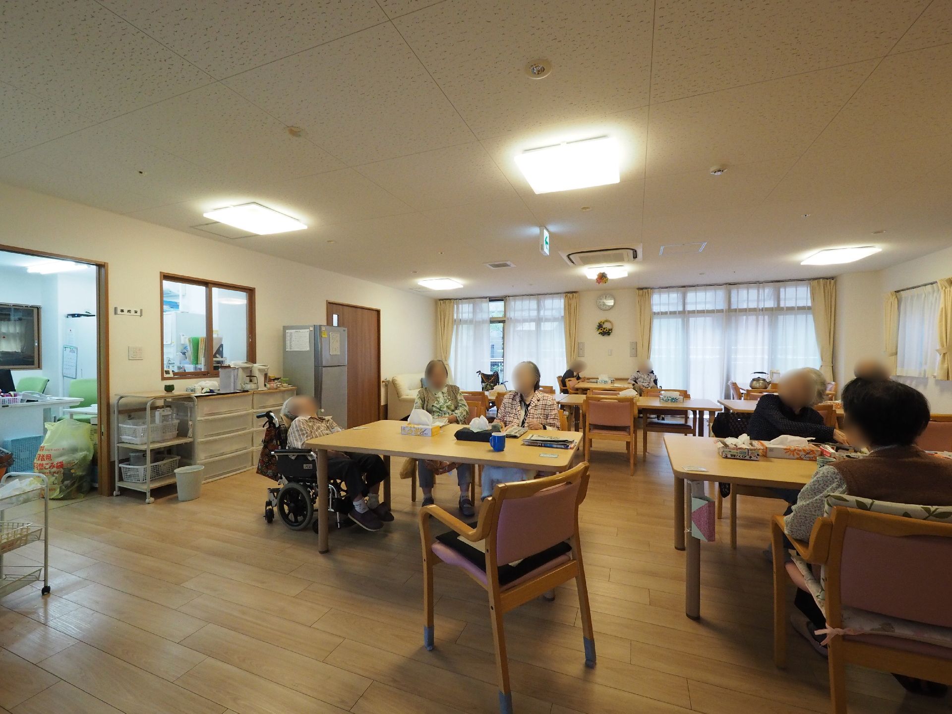食堂に入居者が集まっている様子。眠っていたり、おしゃべりしていたり、それぞれ好みの過ごし方をしている。