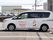 赤い文字で施設名と女の子の絵が入っている白い車両がある。スライドドアのついた大きめのワゴン車である。