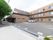 施設外観と駐車場の様子。3階建ての建物はレンガ調の色合いが用いられている。駐車場には車いす専用のスペースがある。