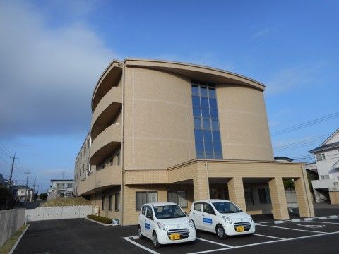 まるでコンサートホールのような、生活感をあまり感じさせない、すっきりとした印象の外観。駐車場も広く車を利用する人にも安心である。