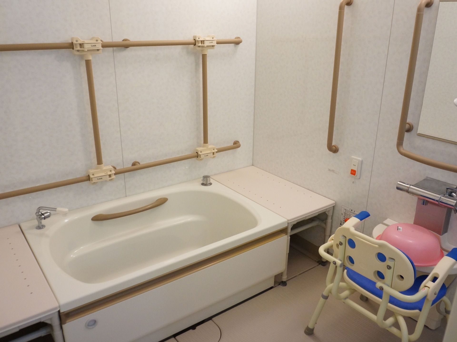 浴室内の壁には、たくさんの手すりが設置されている。ナースコールやシャワーチェア、洗面器も備わっている。