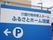 施設では入り口付近のフェンスに青い看板を設置している。大きな文字で施設名を書き、駐車場の方向を案内している。