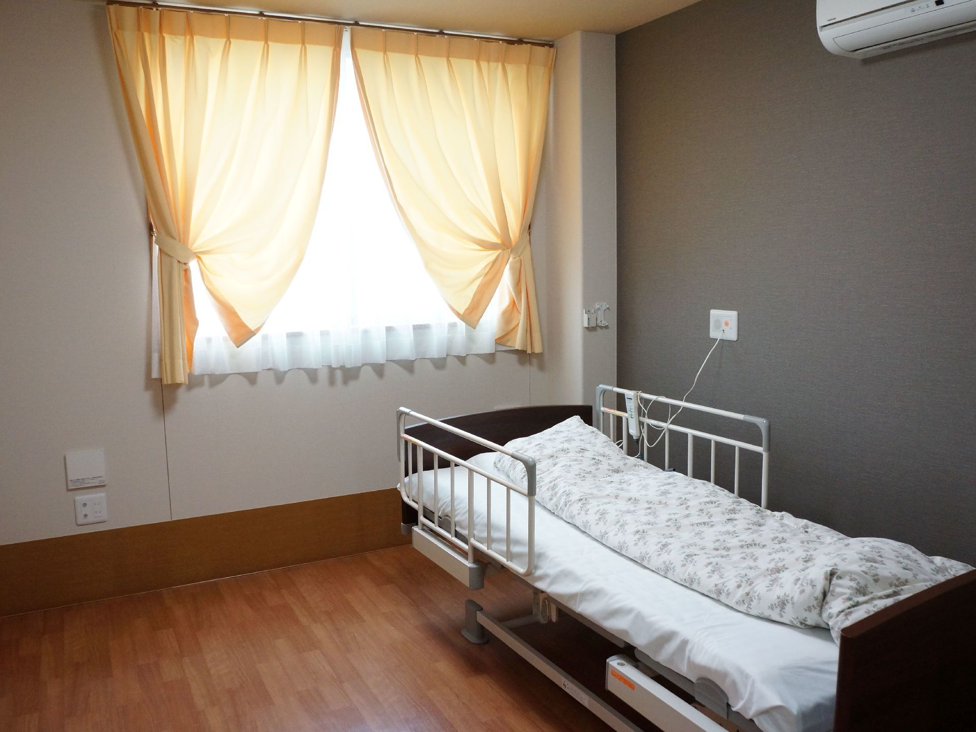 居室の床は全面フラットに整えている。壁には腰高窓を一つ設け、日差しを調整するダブルカーテンを掛けている。