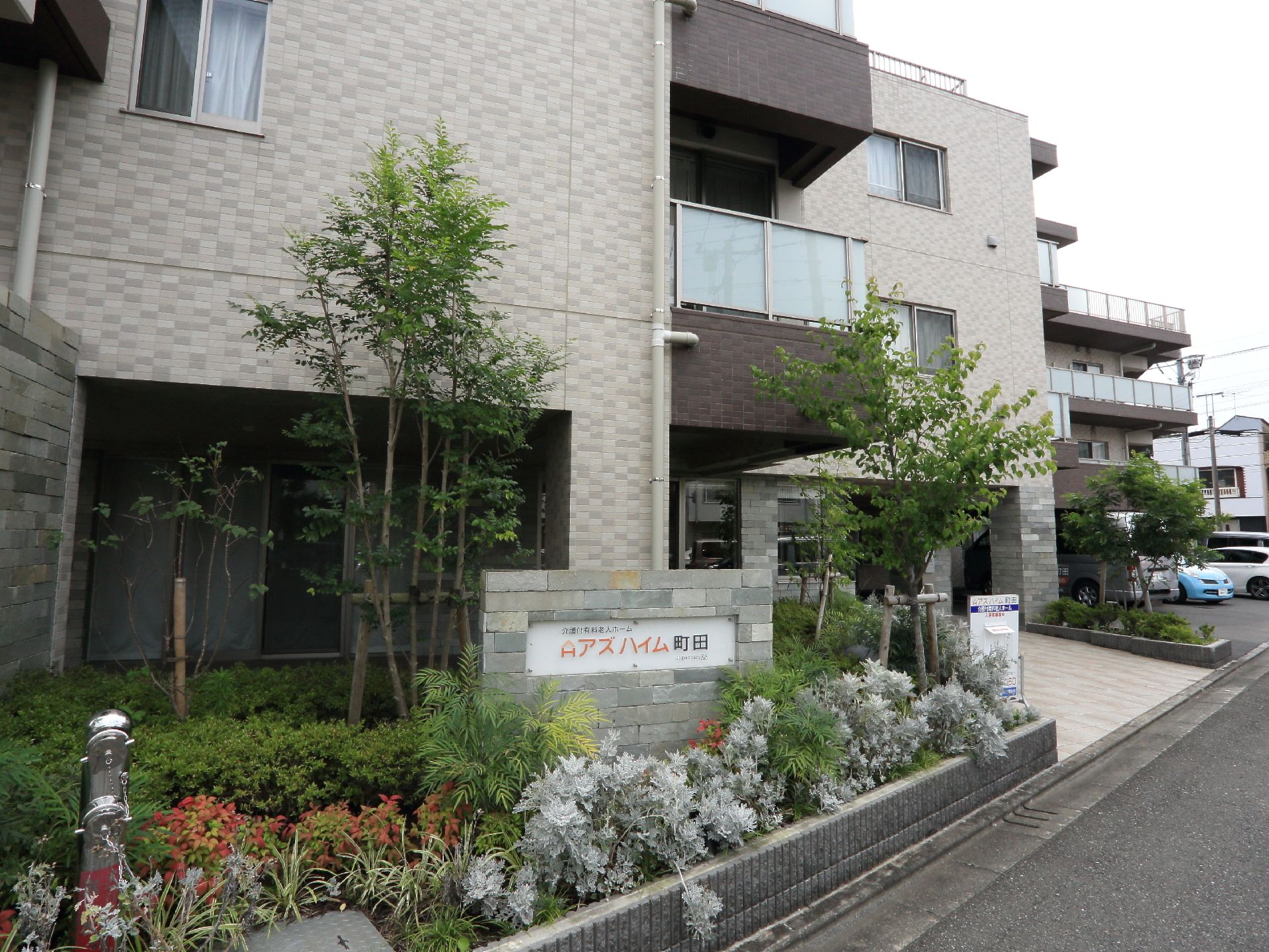ブラウン色を基調とした、落ち着いた雰囲気の緑豊かな施設の外観