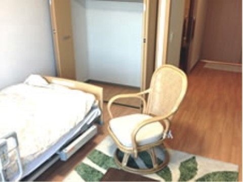 フローリング仕様の居室である。ベッドの後ろにたっぷり収納できる、両開きのクローゼットが完備されている。