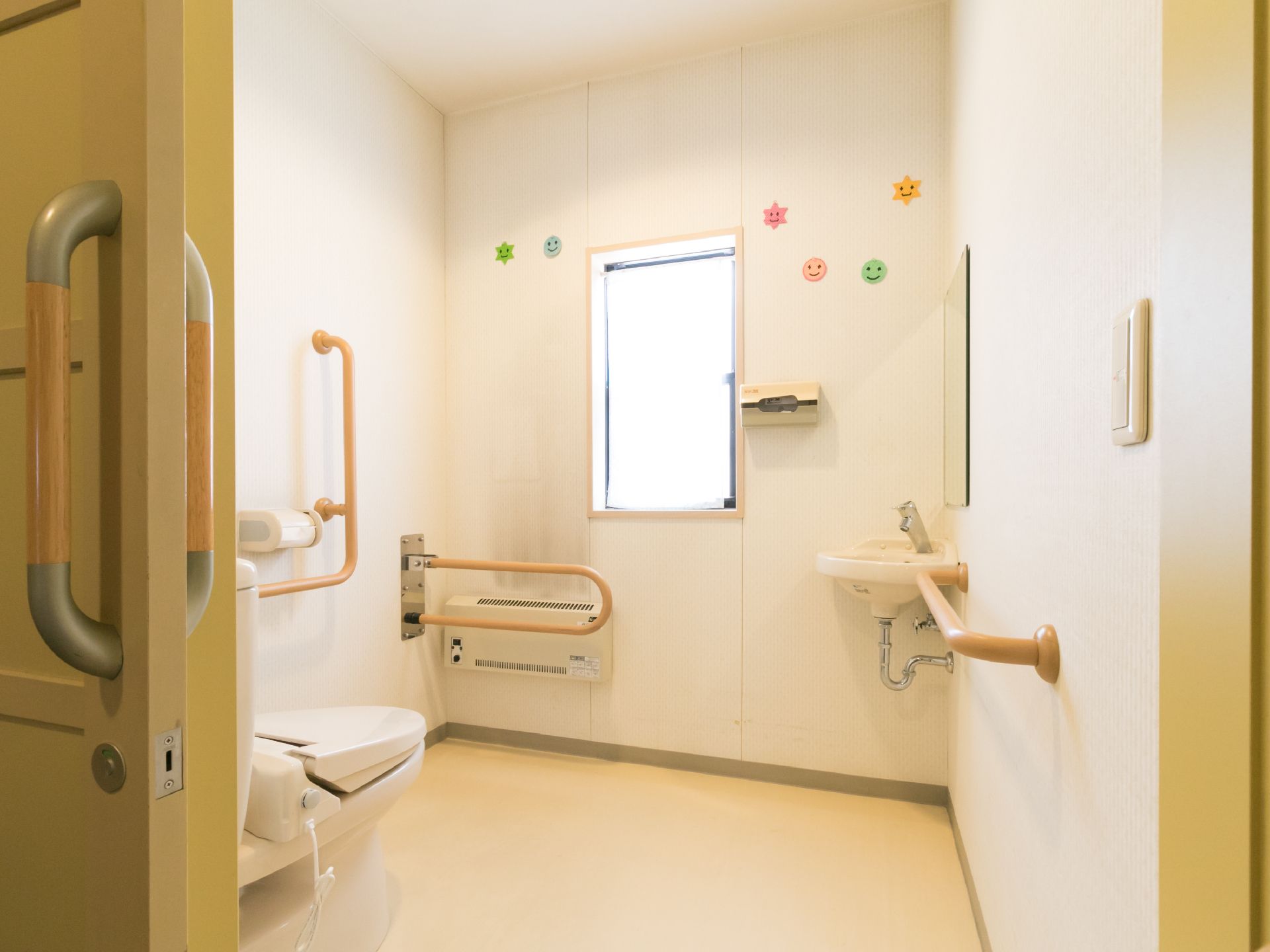 車椅子でも入れる洋式のトイレが用意されている。入り口はスライド式のドアになっており、各所に手すりが設置されている。