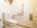 一般家庭にあるのと変わらない洋式トイレが設置してある。加えて、各所に手すりが用意されている。また万一のための緊急ブザーも完備している。