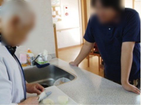 入居者様が調理を行っている時にサポートをしているスタッフ