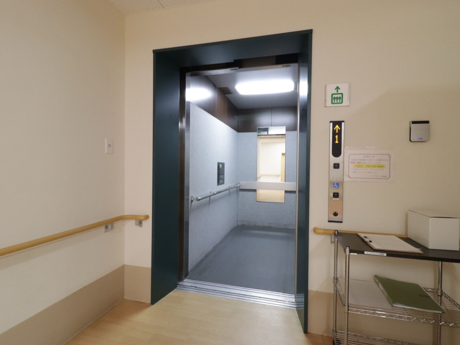 室内に設置されたエレベーター。内部には手すりと鏡がつけられている。シンプルな内部になっており、清潔感がある。