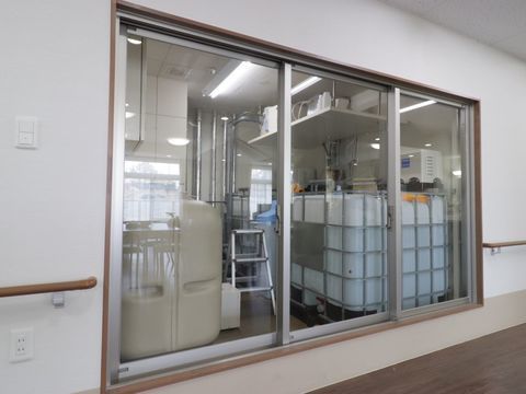 通路には手すりが取り付けられている。そこには大きな窓があり、中が見えるようになっている。中には貯水タンクが並べられている。