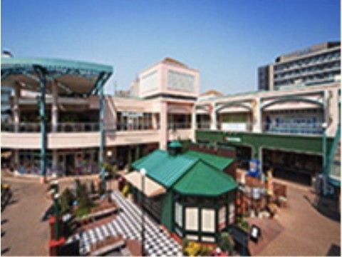 施設のすぐそばには広々としたショッピングセンターがあり、緑色の屋根と白色の壁で統一された外観となっている。