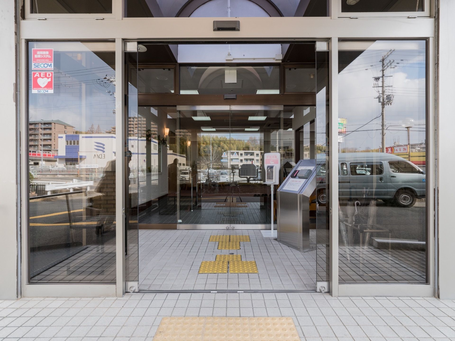 ２重構造の自動ドアになっている。足元には点字ブロックが設置されている。AEDの設置があり、民間のセキュリティー会社と連携している。
