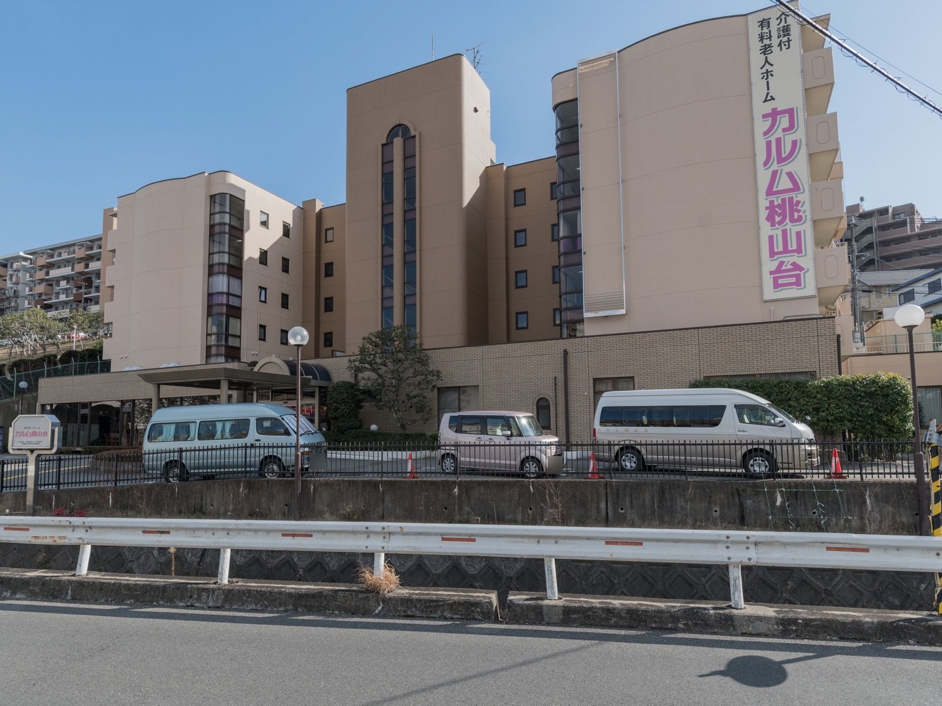 駐車場と敷地外の間に柵を設置している。建物正面は道路のため、日当たりがいい。建物に施設名の書いてある大きな看板がある。