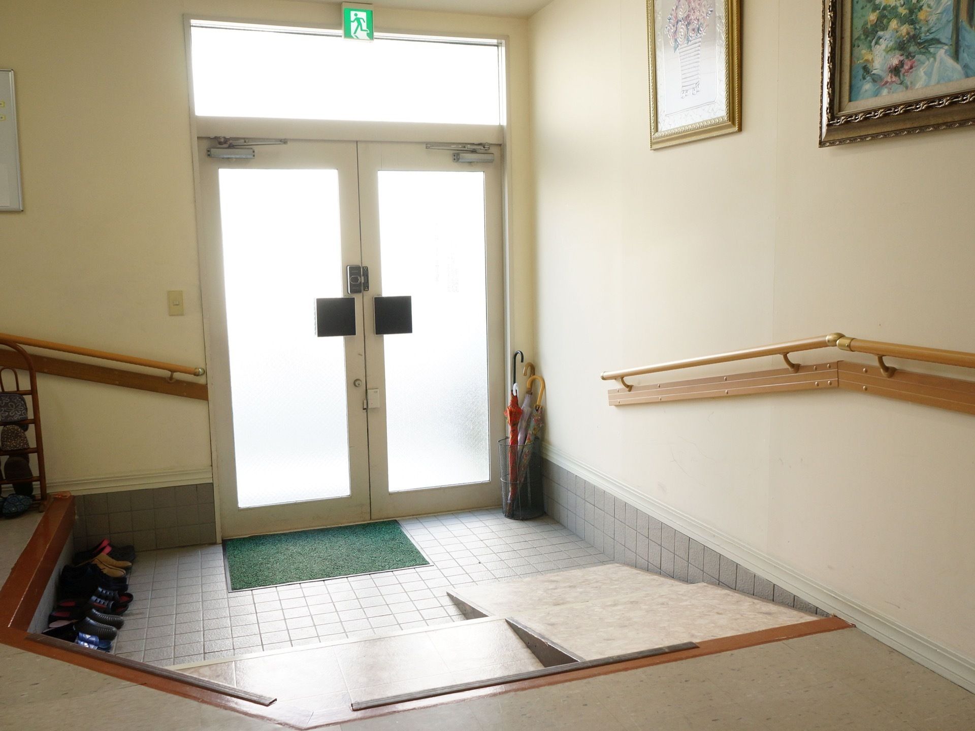 両開きの扉が設置されている。入ってすぐ左に傘立てがある。ゆるい傾斜のステップがあり、その横に手すりが完備されている。