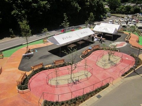 手すり付きの散歩道が広がる大きな庭がある。休憩用のベンチも要所に設置されている。白いテントが張られたスペースがある。