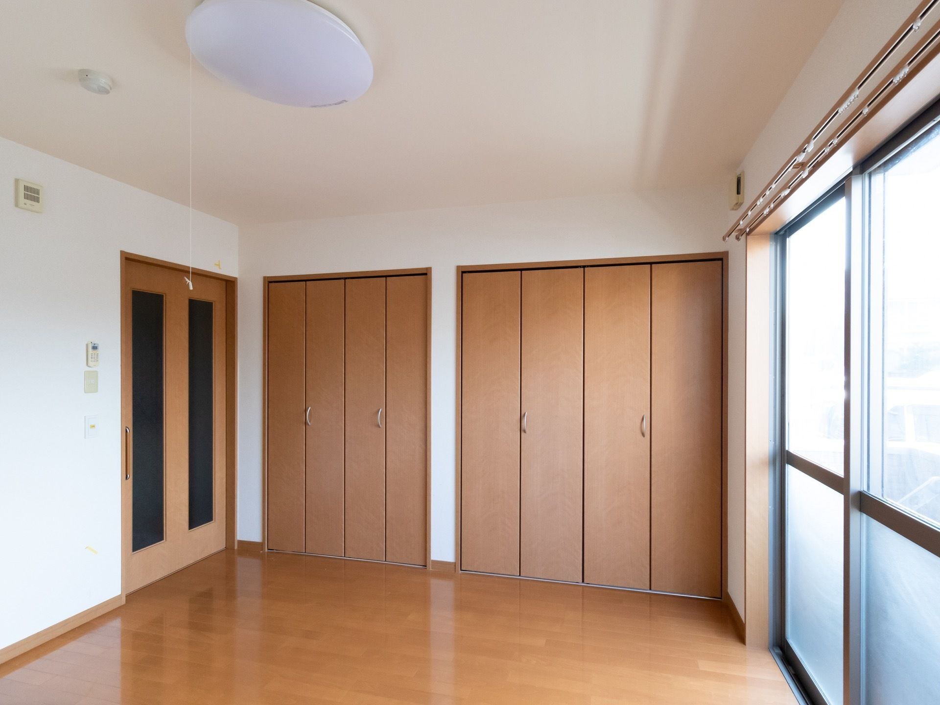 大きな窓のある個室タイプの居室で、フローリングの洋室となっている。天井には紐の付いた照明が設置されている。