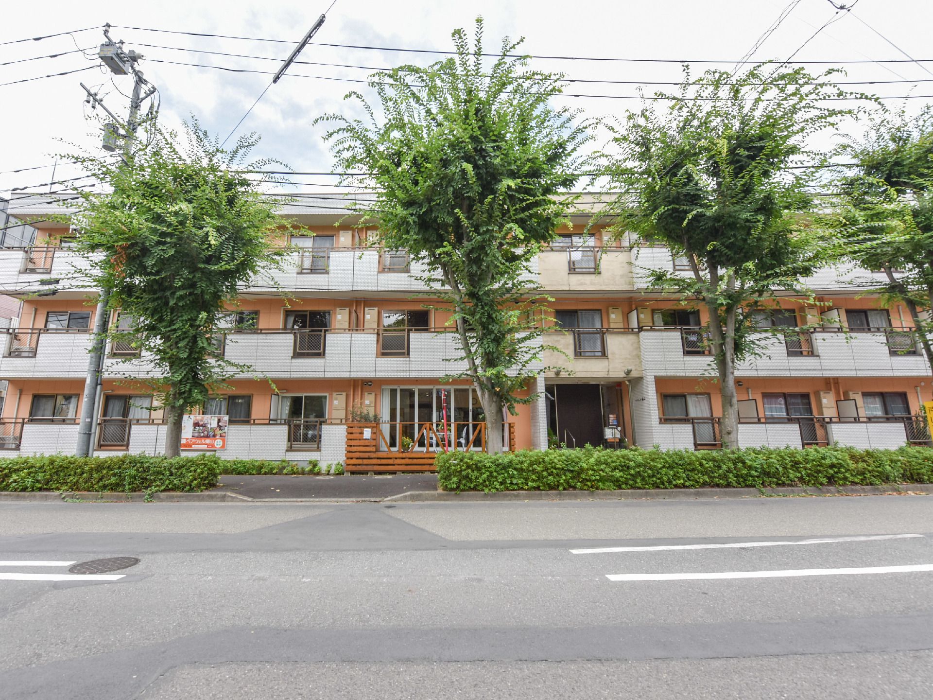 施設は3階建ての建物である。それぞれの階にフェンスが設置されたベランダがある。前面には大きな木が植えられている。