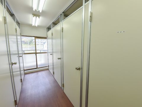 トランクルームの床はフラットなフローリングで、正面には掃き出し窓が設けられている。天井には複数の蛍光灯がある。