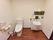木目調の床に白色の壁で造られた、広々としたトイレである。手すりが壁に備えつけられている。オストメイト対応になっている。