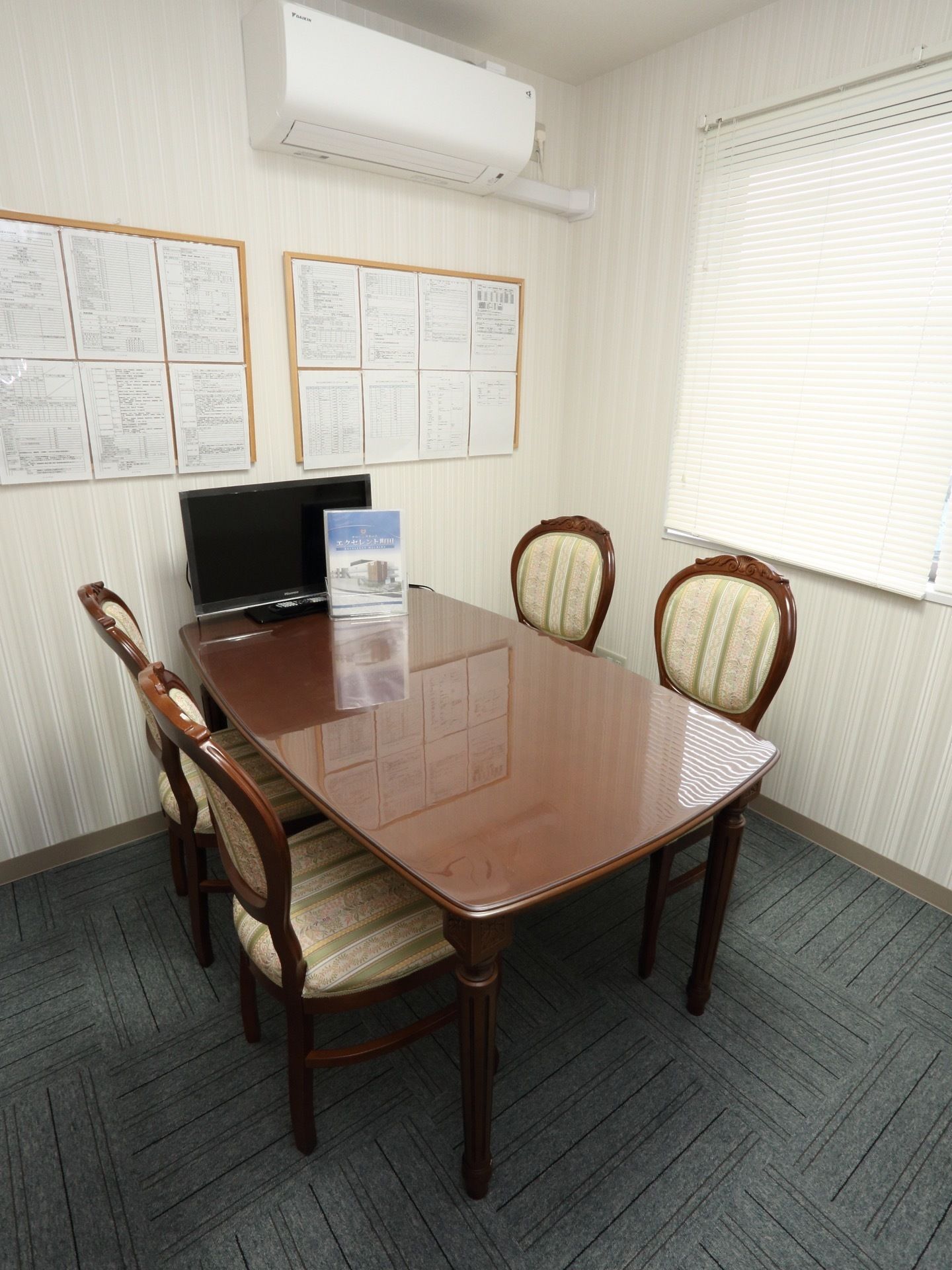 相談室は、４人掛けのテーブルと施設の資料だけが置いてある小さな部屋である。テーブルと椅子にはこだわりが見られ、部屋の雰囲気が和らいでいる。