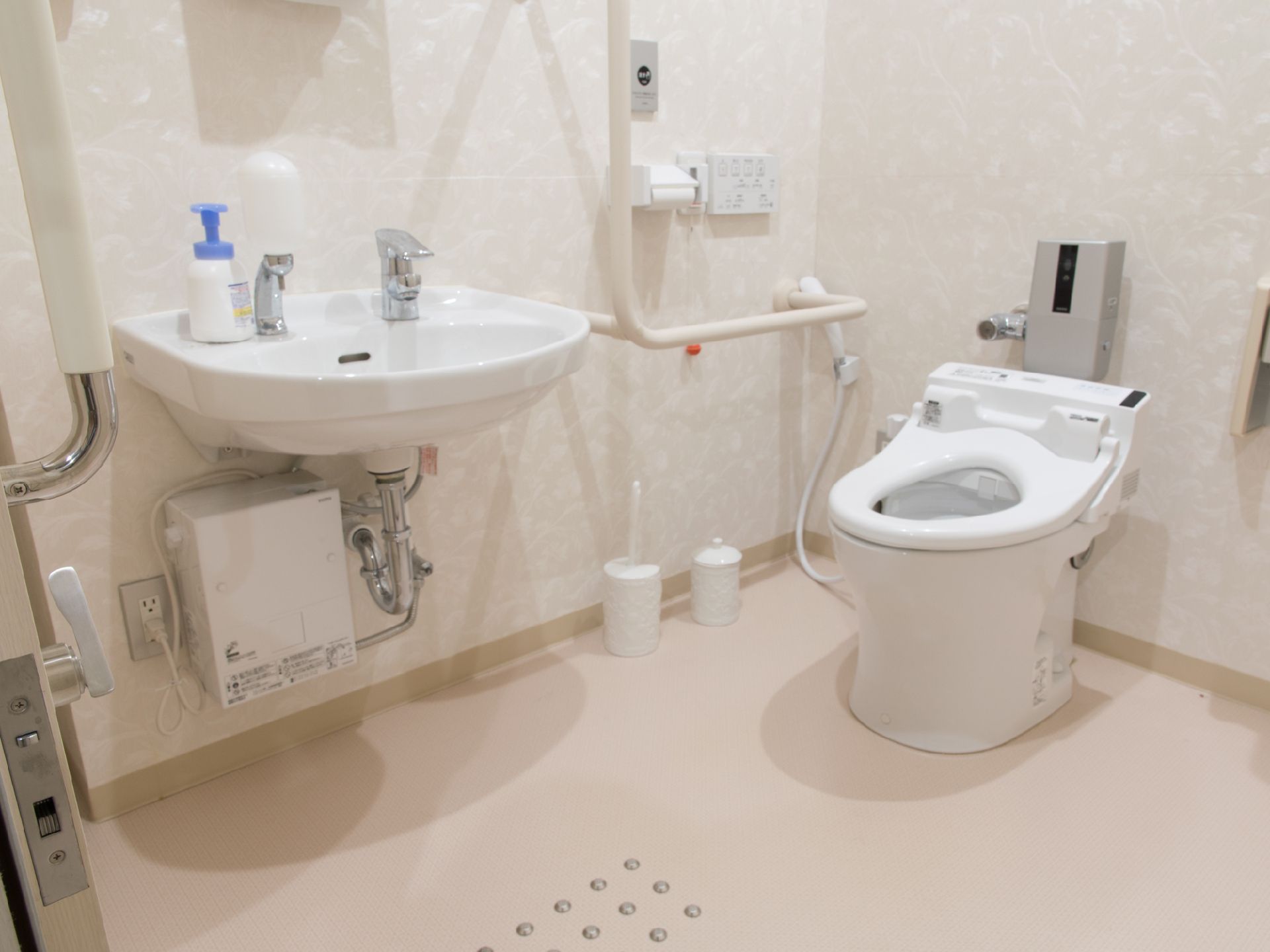 シングルレバー蛇口がついた手を洗う場所と、洋式トイレがある。ウォッシュレットと、シャワーがついたタイプで、壁に操作パネルがかけてある。