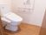 床はフローリングになっていて、白壁のトイレである。洋式で、座部の隣にウォシュレットの操作ボタンがついている。