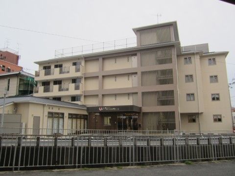 落ち着いた配色の４階建ての建物である。玄関前には駐車するスペースがあり、車でも問題なく利用可能である。
