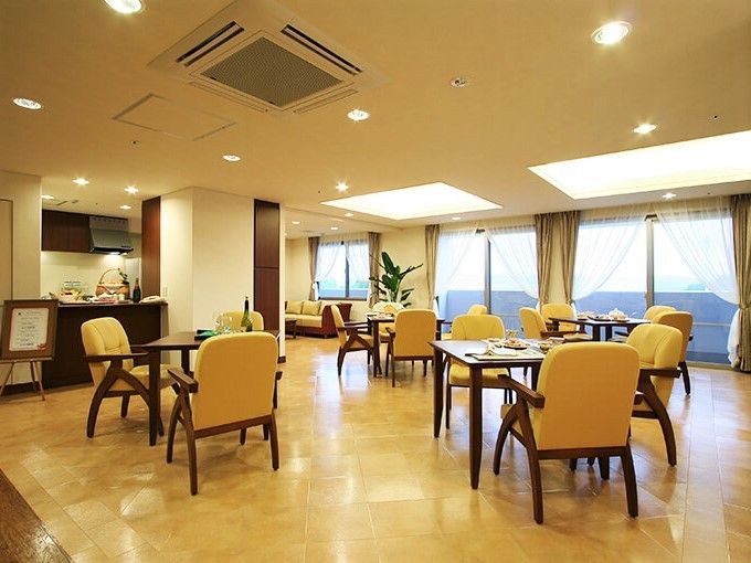 山吹色の座面がついた椅子と木製のテーブルが並んだ部屋。