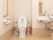 両サイドに手すりがついた洋式トイレがある。ハンドソープが置いてある手洗い場が別に設けてある。塵取りがある。