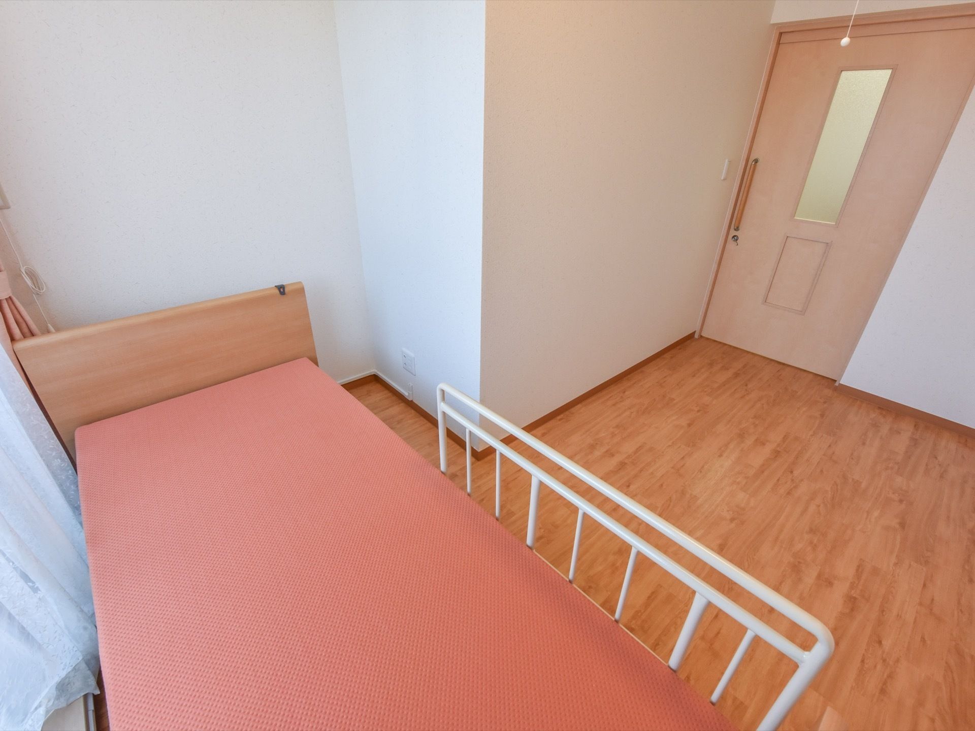 広い居室の床は、フローリングになっている。壁は淡い薄茶色で、落ち着いた雰囲気の部屋である。ドアは引き戸式になっている。