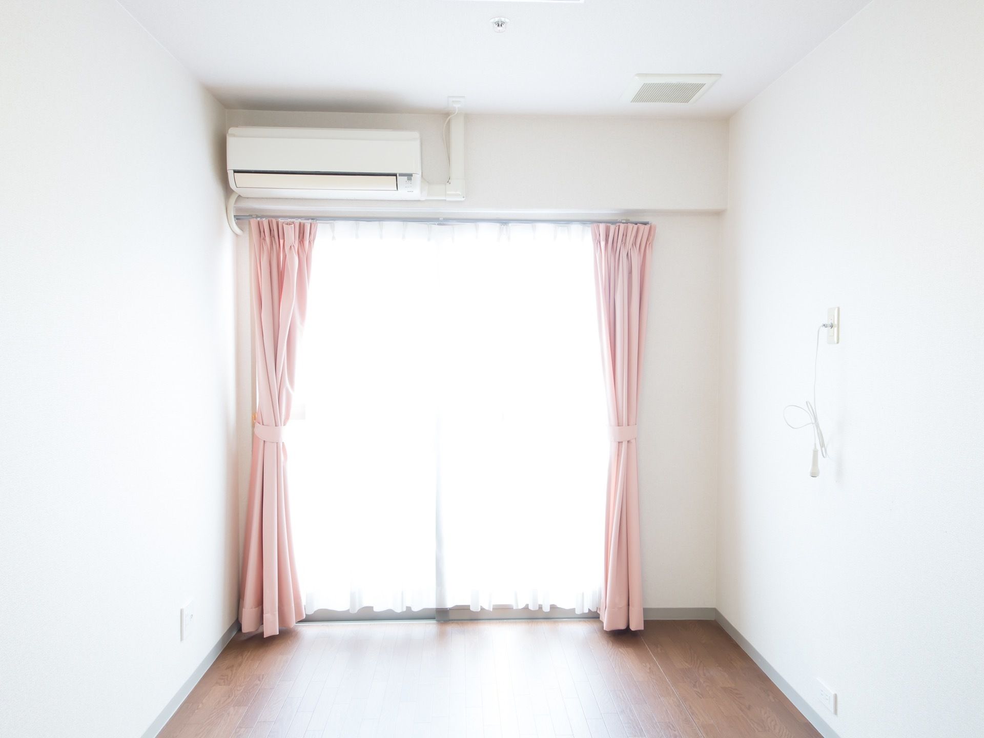明るい居室には淡いピンク色のカーテンが掛けられている。色彩の調和の取れた落ち着いた雰囲気の空間となっている。