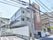 建物の階上を見上げるとガラス張り側面が目に留まる。明るい陽射しが注ぐ開放的な設計になっているのは2階3階の廊下部分。