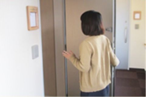 部屋のドアを開ける女性