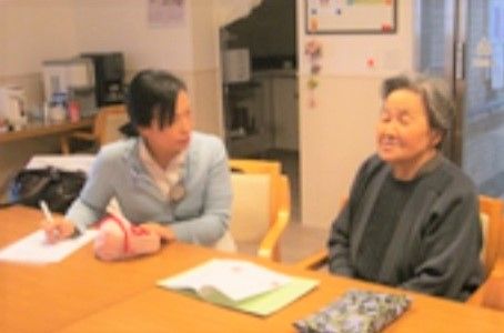 高齢者のヒアリングをする女性スタッフ
