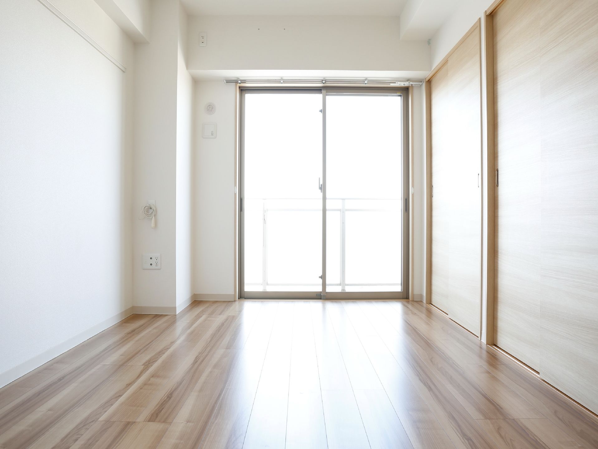 居室の床はフローリング張りとなっている。窓からは明るい光が差し込む。室内入って右手にあるのは収納の扉。