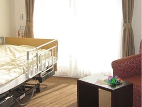 転落防止柵が付いたベッドが設置された、陽射しが差し込む居室